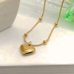 Colar bolinha com pingente coração em aço inox dourado, delicado e ideal para presente feminino. - Imagem 4
