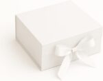 Caixa de Presente Premium Branca: rígida, com trava magnética e laço de cetim para presentear com elegância e segurança.