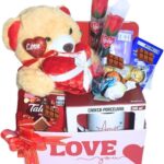 Cesta Namorados Premium com chocolate suíço, urso e caneca: presente romântico, sofisticado e pronto para emocionar.