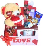 Cesta Namorados Premium com chocolate suíço, urso e caneca: presente romântico, sofisticado e pronto para emocionar.