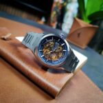 Relógio Orient Skeleton automático: estilo sofisticado com fundo azul/dourado e correia prateada para quem busca elegância. - Imagem 2